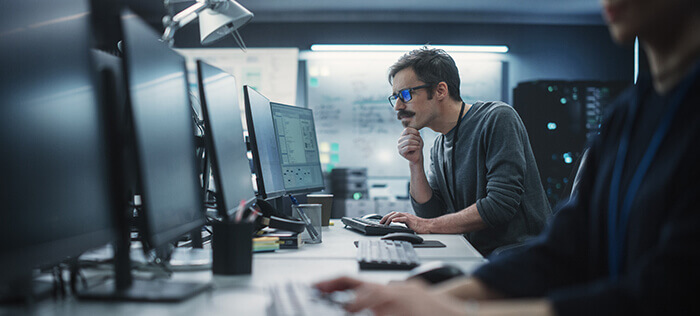 Portrait of a Thoughtful Engineer Working on Desktop Computer in a Technological Office Environment